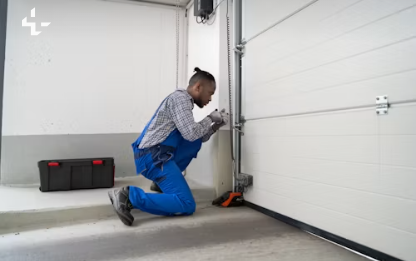 Technician kneeling to fix a garage door track quickly, fast response example