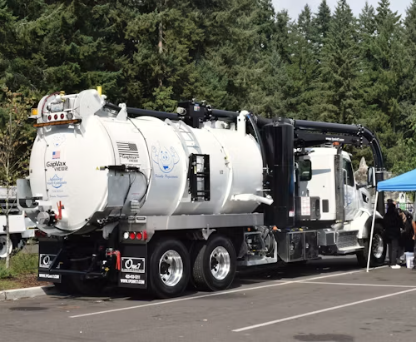 septic-vacuum-truck-forest Septic vacuum service truck parked at a wooded job site, scheduled maintenance plan example